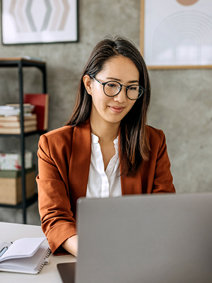 A lady looking at her computer in her office. 